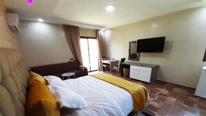 A hotel room with a bed, a desk, a chair, a television, and a window with curtains. - Bungalow in Marrakech 4439 (Marrakech)