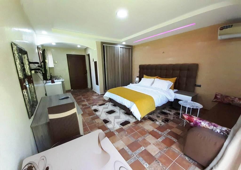 Una habitación de hotel con una cama, un escritorio, una silla y una mesita.
