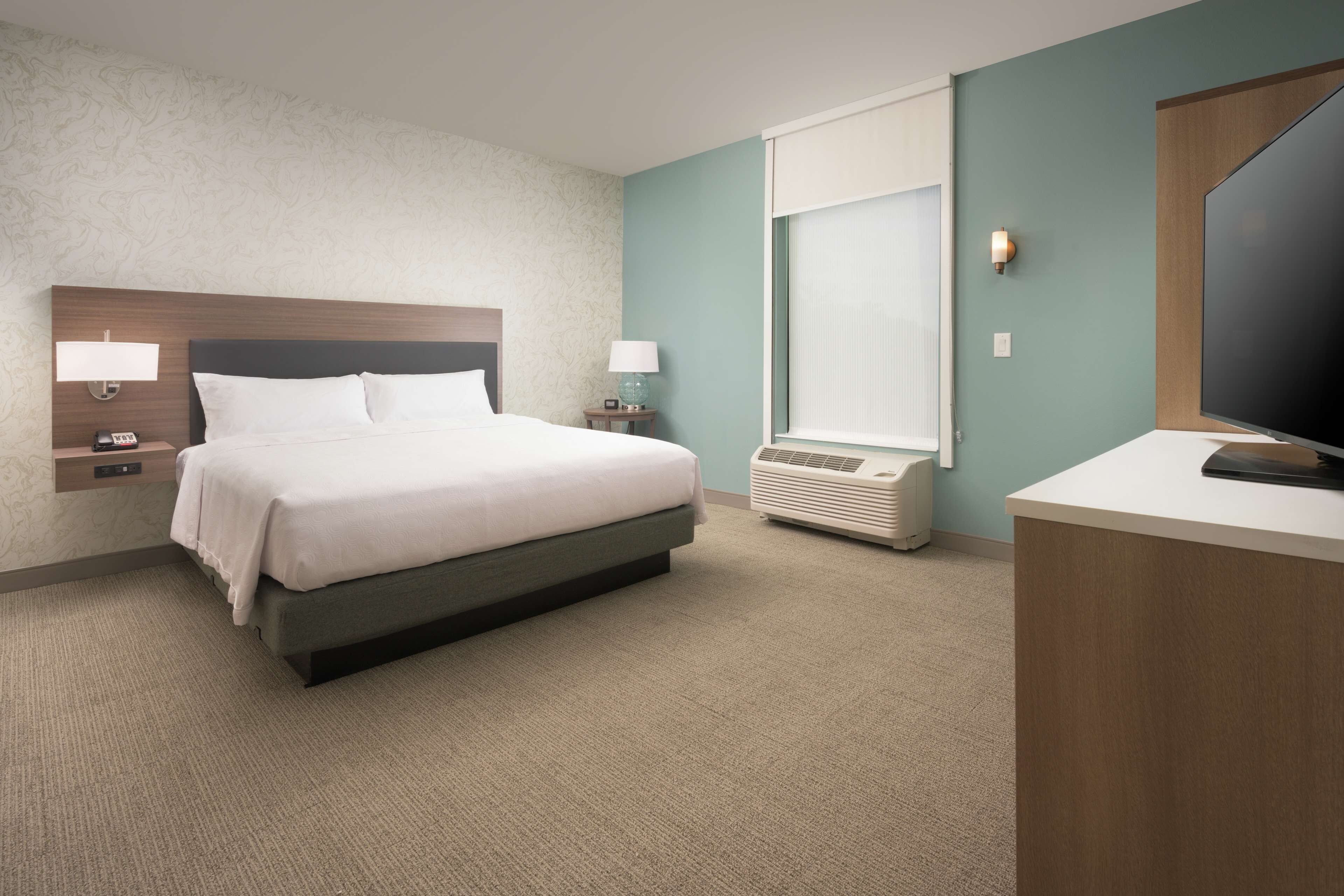 desk, laptop workspace, iron/ironing board, bed sheets