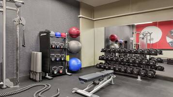 Uma academia com equipamentos de ginástica, pesos e bolas de exercício.