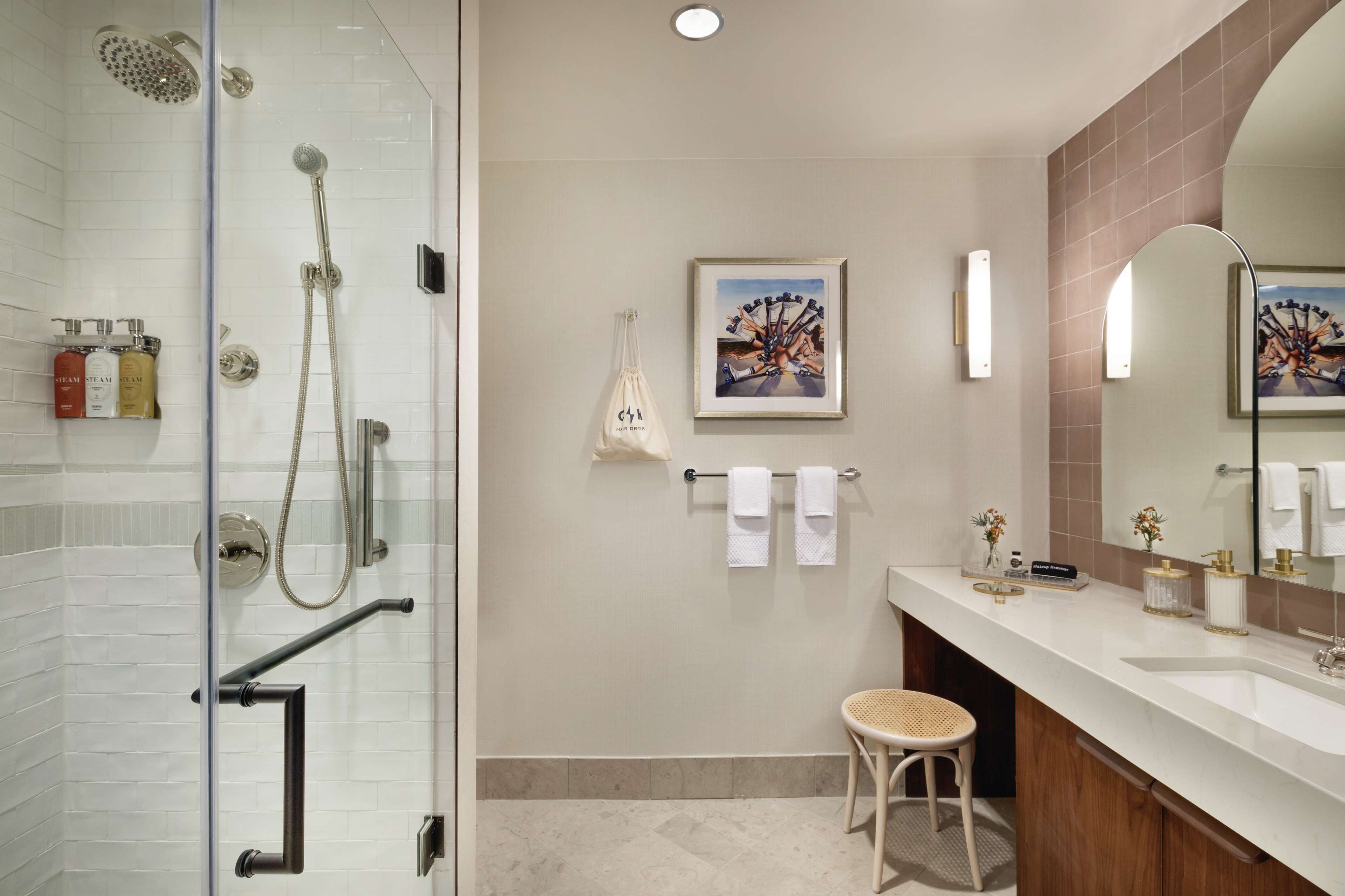 A modern bathroom with a glass-enclosed shower, a vanity with a sink, and a large mirror.