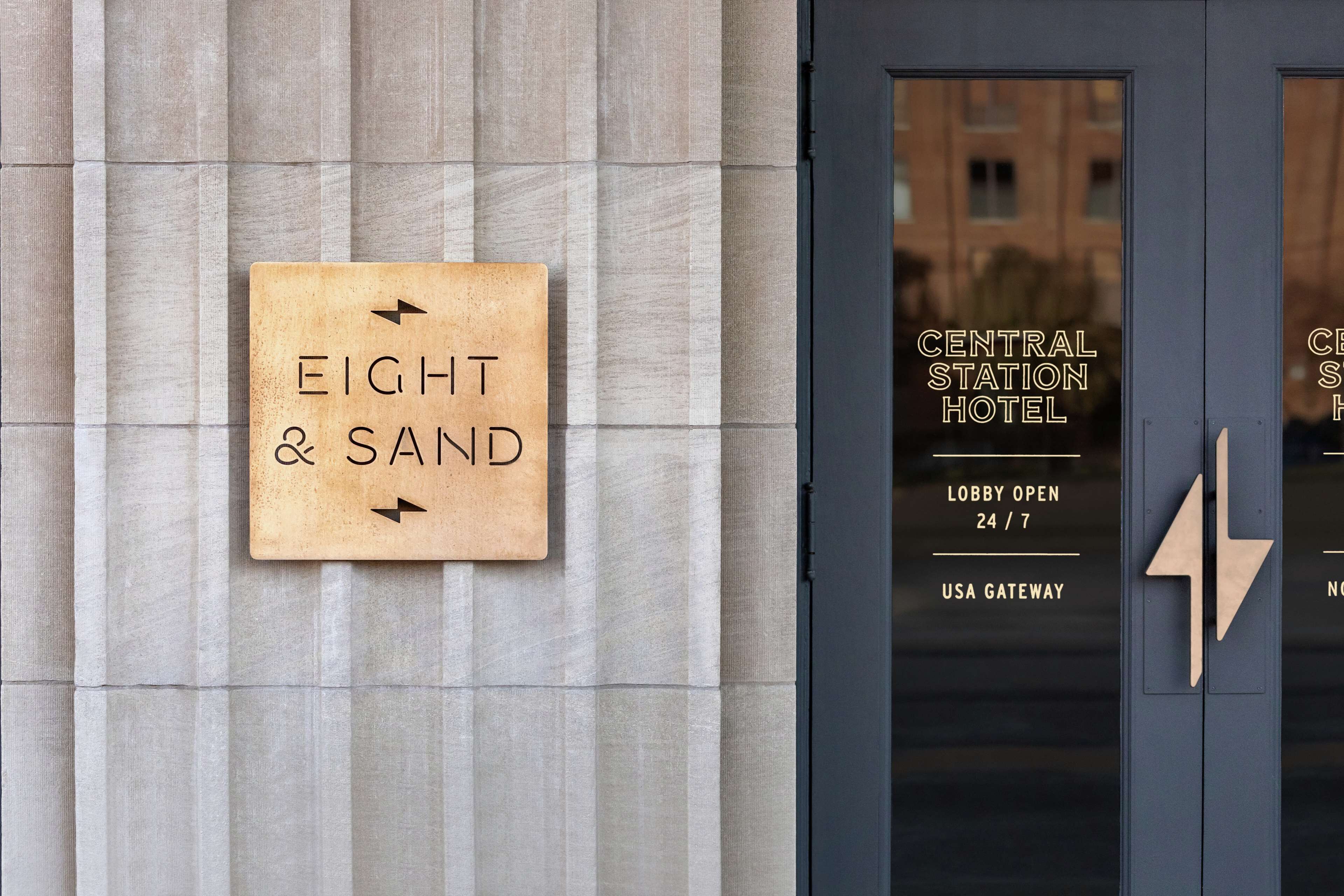 A sign for 'EIGHT & SAND' hotel with a directional arrow, and a door with 'CENTRAL STATION HOTEL' and 'USA GATEWAY' signage.