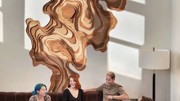 Un intérieur moderne agrémenté d'une œuvre d'art murale originale en bois, de sièges confortables et d'une table avec des boissons.