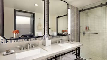 Een moderne badkamer met twee wastafels, een grote spiegel en een douche met glazen wanden.