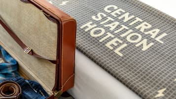 A suitcase with a brown leather exterior and a rolled-up pair of jeans inside.