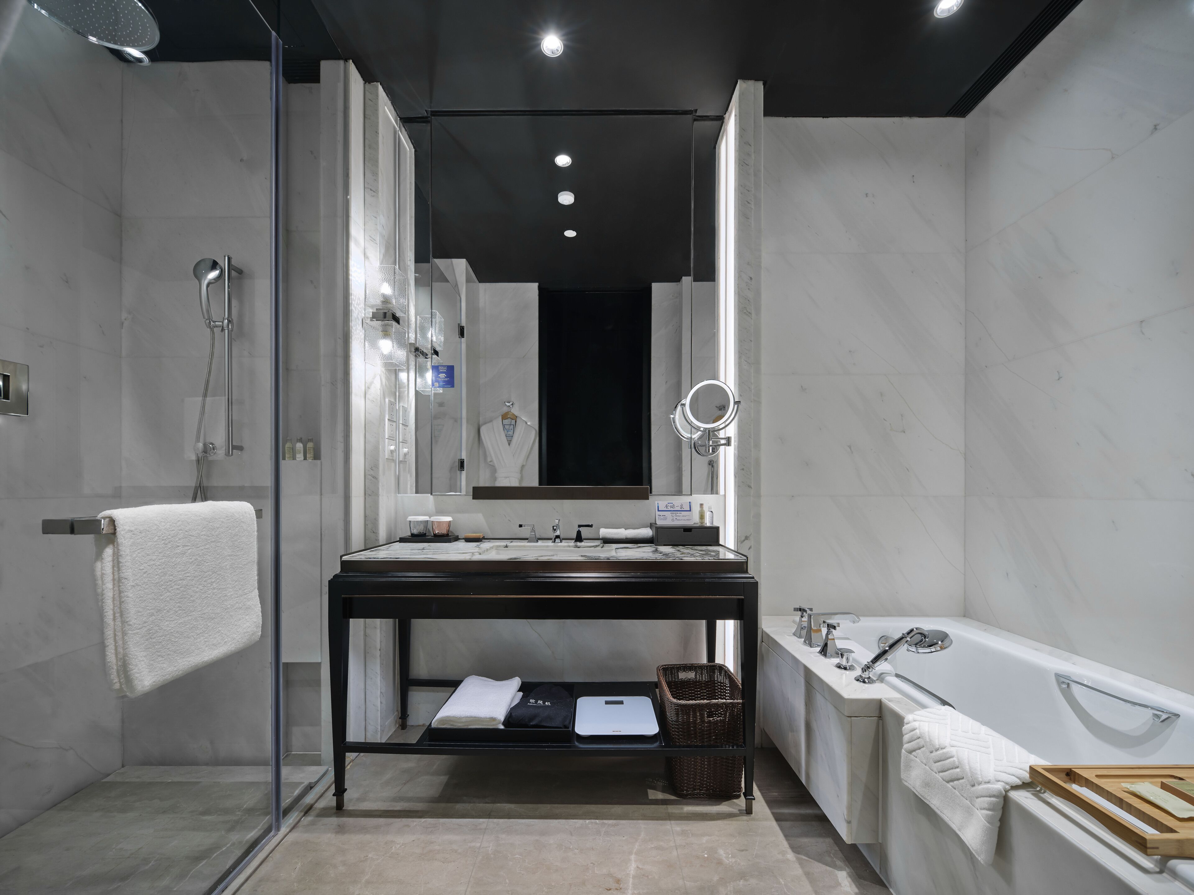 A modern bathroom with a glass-enclosed shower, a vanity with a mirror, a bathtub, and a sink.