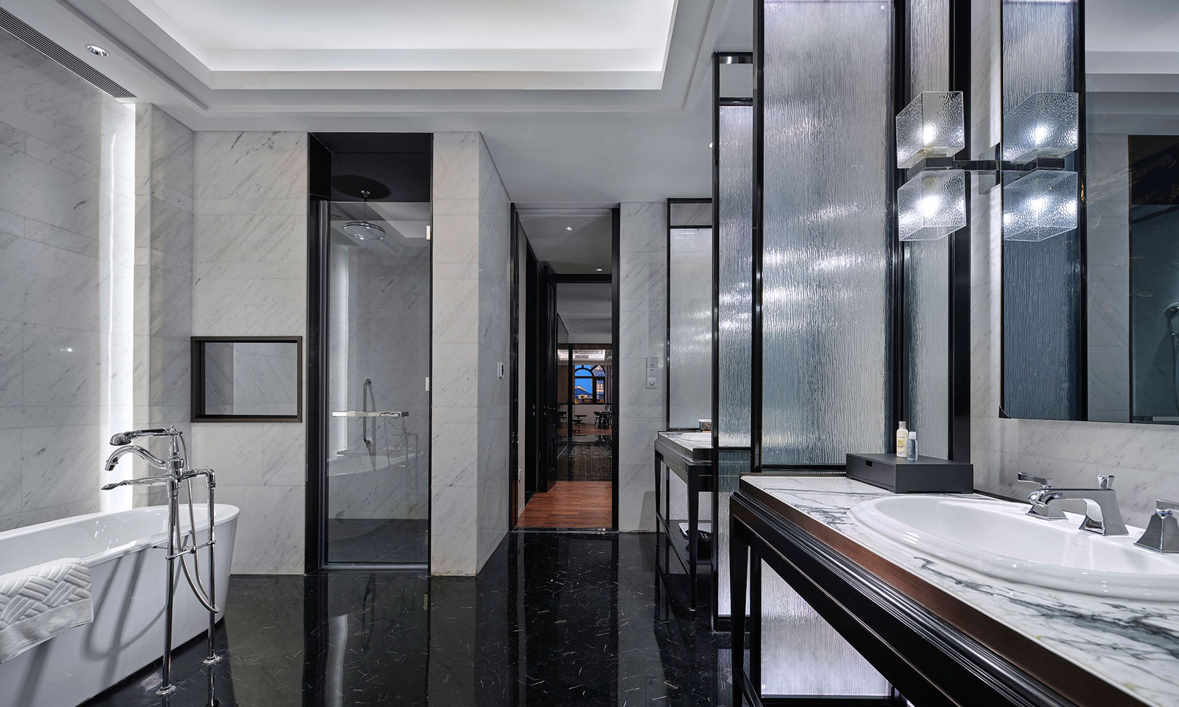 Un baño moderno con un espejo grande, una bañera y un tocador con lavabo.