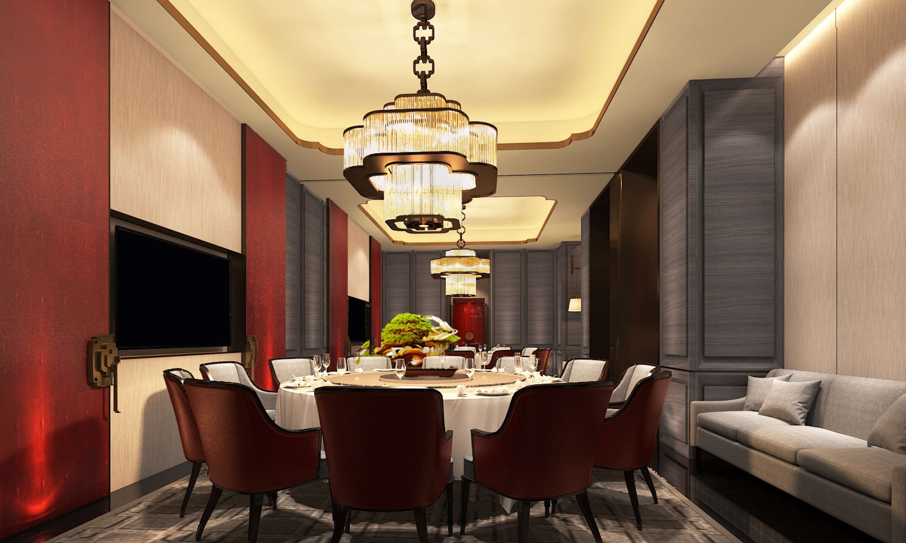 A modern dining room with a round table, multiple chairs, a chandelier, and a sofa.