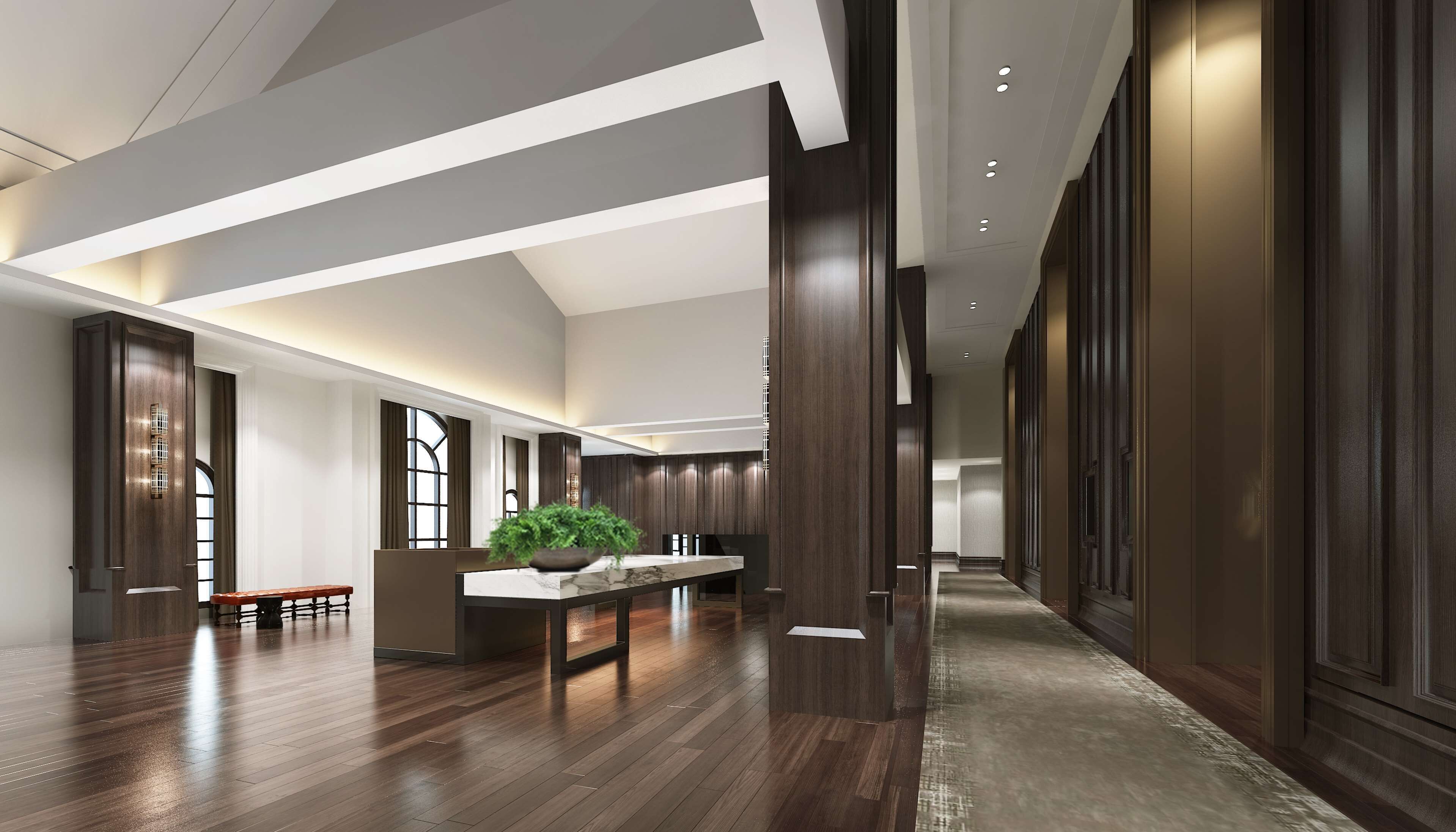A spacious hotel lobby with a high ceiling, wooden flooring, a central seating area with a marble table, and a large potted plant.