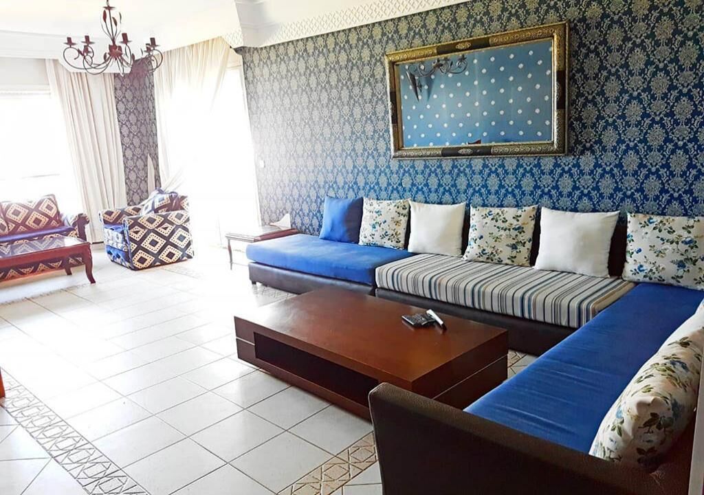 A living room with a sofa set, a coffee table, and patterned cushions.