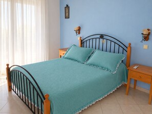A bed with a headboard, two bedside tables, and a nightstand.