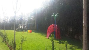 A grassy outdoor area with playground equipment, including a slide and climbing structures. - Very Nice apartment in Eden Tamaris 4175 (Dar Bouazza)