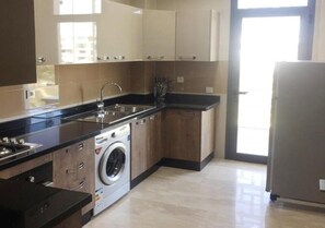 A modern kitchen with a built-in washing machine, a sink, and a refrigerator.