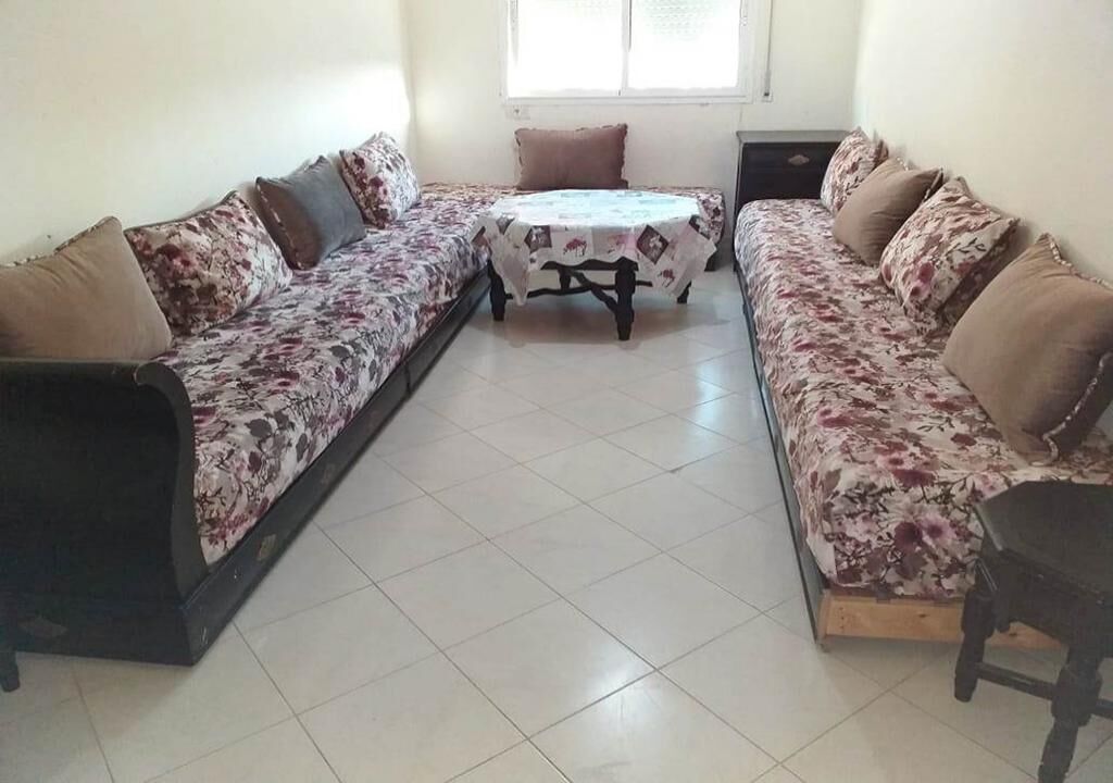 Ein Zimmer mit zwei Sofas, einem kleinen Tisch und einem Sessel.