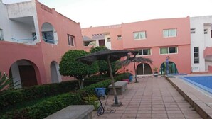 Ein Innenhof mit Swimmingpool, Topfpflanzen und einem Fahrrad.
