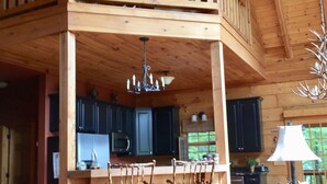 A spacious cabin with a loft bedroom, a dining area, and a kitchen.