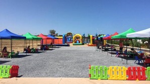 Un espace événementiel en plein air agrémenté de tentes colorées et de structures gonflables.