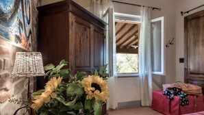 A room with a wooden cabinet, a wicker lamp, and a window with curtains. - Villa Bellaria, in the heart of Tuscany (Lucignano)