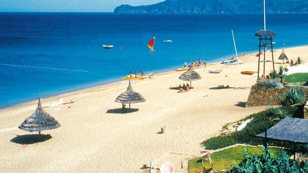 A beach with thatched umbrellas, a lifeguard tower, and boats in the water. - Apartment in Saidia 4305 (Saidia)