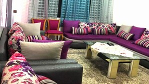 Ein Wohnzimmer mit einer Sofagarnitur, einem Couchtisch und einem gemusterten Teppich.
