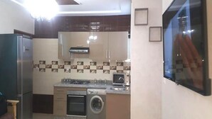 A modern kitchen with a built-in oven, microwave, and washing machine. - Apartment 5 minutes from the beach 4253 (Saidia)