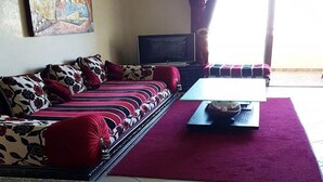 Una sala de estar con un sofá, un televisor y una mesa de centro.