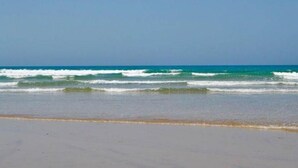 Una playa con olas y cielo despejado.