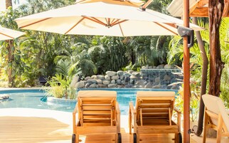 室外游泳池，池畔遮阳伞，日光浴躺椅