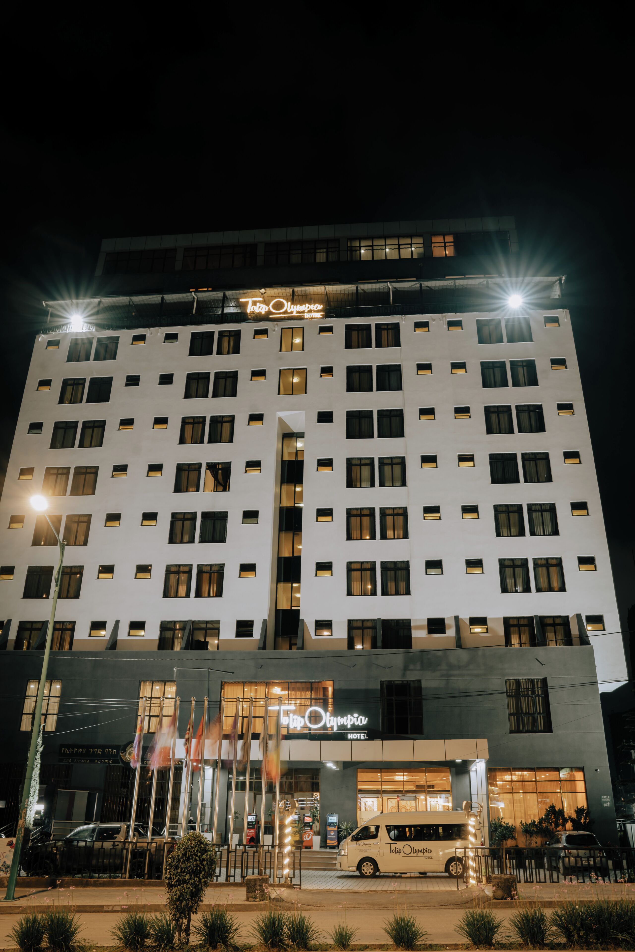 Un hotel con fachada moderna, varios pisos y un letrero llamativo en la parte superior.
