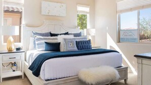 A bedroom with a white bed, multiple pillows, a nightstand, a lamp, and a window with a view. - PVZ40|Steps to Pools *SplashPad* HotTub*GreenSpace (Santa Clara)