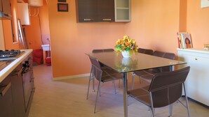 Une cuisine moderne avec une table et des chaises, un fourneau et un meuble de rangement.