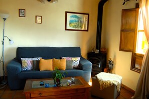 Una sala de estar con un sofá azul, una mesa de centro de madera y una chimenea.