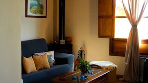 A living room with a sofa, a coffee table, and a fireplace.