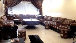 A living room with a sofa set, a coffee table, and patterned ottomans. - Apartment in Islane Agadir 4468 (Agadir)