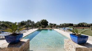 A rectangular swimming pool with clear water, surrounded by stone walls and blue planters with plants. - Finca Sa Pletassa, Villa with Private Pool (Horta, S' (Felanitx))