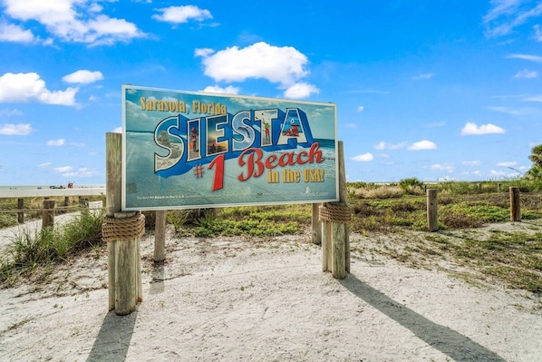 A beach sign with the text 'Sarasota, Florida, #1 Beach in the USA.'