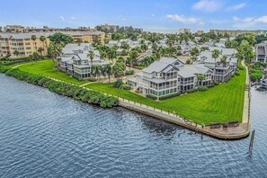 A waterfront residential area with modern houses, a dock, and a clear view of the water.