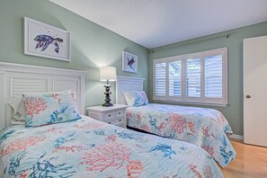 A bedroom with two beds, a nightstand, a lamp, and a window with blinds. - Siesta Bayside Villa: Water Views & Private Beach (Siesta Key)