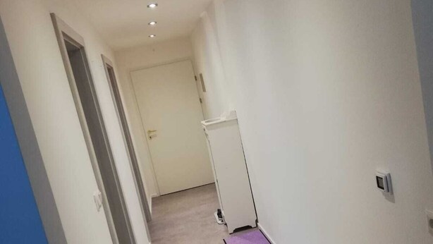 A narrow hallway with a carpeted floor, white walls, and recessed lighting. - New renovated apartment in a central location (Kundl)