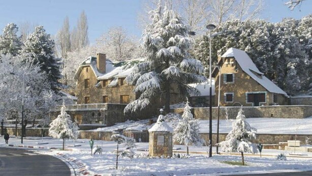 A stone building with a snow-covered roof and a small tower. - Sublime Floor Villa in Ifrane 4172 (Ifrane)