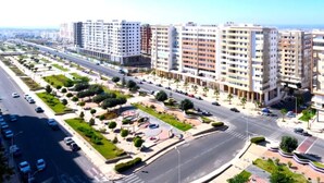 A modern residential area with multi-story apartment buildings, wide roads, and landscaped areas.