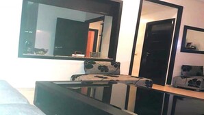 Une pièce comprenant un lit, un canapé, une table basse et deux grands miroirs sur le mur.