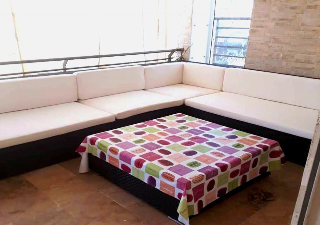 A corner seating area with a colorful quilted tablecloth.
