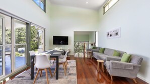 Amplia sala de estar con mesa de comedor, sofá y televisor.