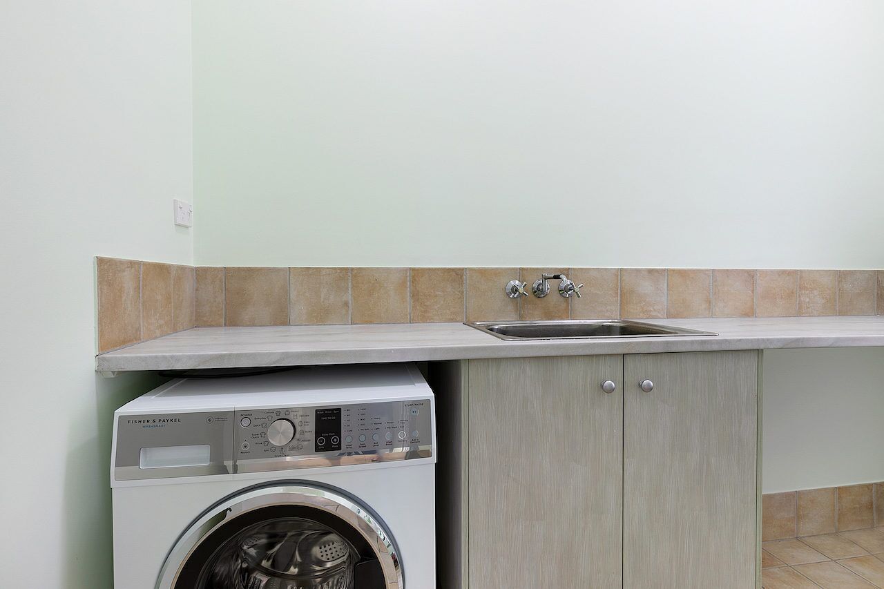 A compact kitchen with a built-in washer and a sink.