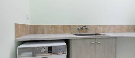 A compact kitchen with a built-in washer and a sink.