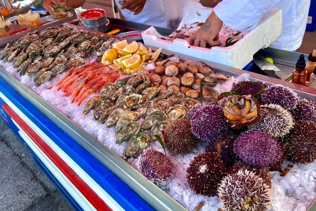 A seafood display with various types of shellfish and shrimp on ice.