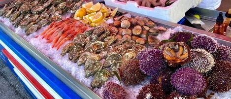 A seafood display with various types of shellfish and shrimp on ice.
