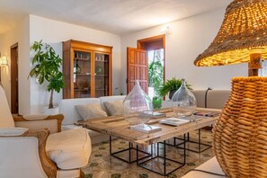 Un salon chaleureux avec une table basse en bois, un canapé et une lampe en osier.