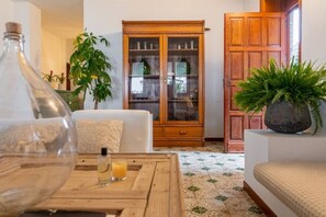 Uma sala de estar com sofá, um armário de madeira e um vaso com planta.